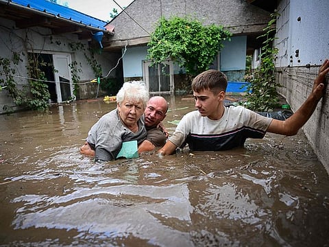 Local residents rescue an elderly woman from the rising flood waters in the Romanian village of Slobozia Conachi.