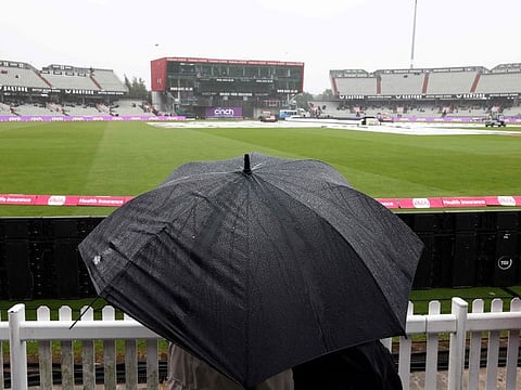 Rain drops fall on an umbrella as the 3rd 'Vitality IT20' Twenty20 International cricket match between England and Australia is delayed at Old Trafford, in Manchester, on Sunday.