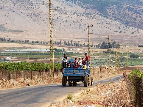 Syrian refugees leave the southern Lebanese village of Wazzani after the Israeli army dropped leaflets calling for them to evacuate on September 15, 2024.