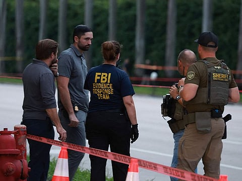 Law enforcement personnel investigate the area around Trump International Golf Club after an apparent assassination attempt of former President Donald Trump.