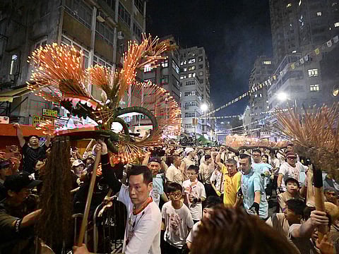 Members of the fire dragon dance team spin balls of joss sticks during the Tai Hang Fire Dragon Dance, in Hong Kong.