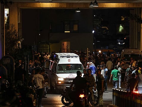 Ambulances are surrounded by people at the entrance of the American University of Beirut Medical Center after explosions hit locations in several Hezbollah strongholds around Lebanon.