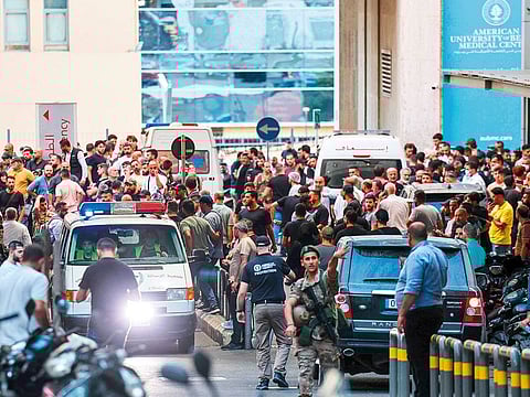 Ambulances are surrounded by people at the entrance of the American University of Beirut Medical Centre yesterday, after explosions hit several Hezbollah strongholds around Lebanon.