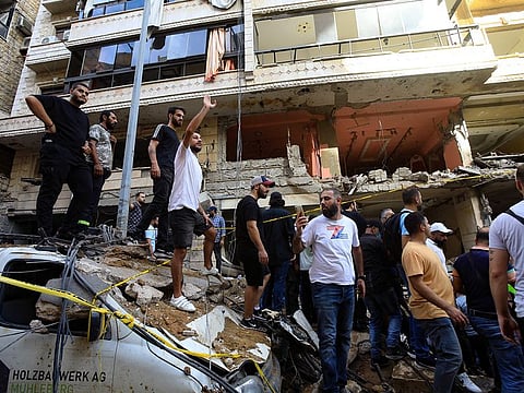 People gather in front of a building targeted by an Israeli strike in Beirut's southern suburbs on September 20, 2024.