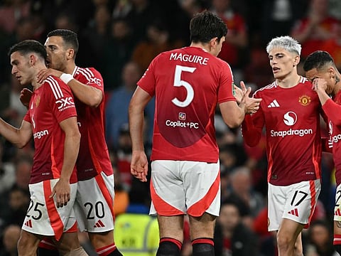 Manchester United's midfielder Alejandro Garnacho (2R) celebrates scoring the team's fourth goal with teammate Harry Maguire and Casemiro during the English League Cup third round football match against Barnsley at Old Trafford on September 17.