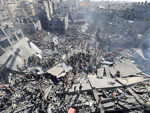 File photo: People search for survivors and the bodies of victims through the rubble of buildings destroyed during Israeli bombardment, in Khan Yunis in the southern Gaza Strip on October 26, 2023.