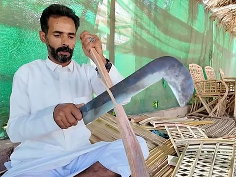 Ebrahim Al Huwaiti works on manufacturing furniture from palm fronds.