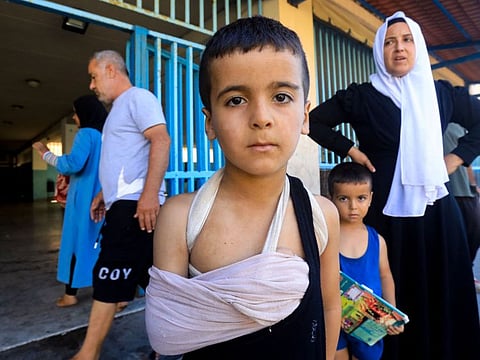 An injured child poses for a picture at a school in Beirut housing displaced people who fled Israeli strikes in southern Lebanon, on September 26, 2024.