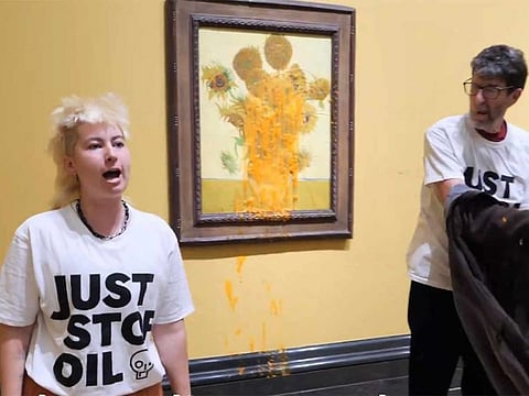 Screengrab from a video shared by Just Stop Oil showing the activists beside the paining.