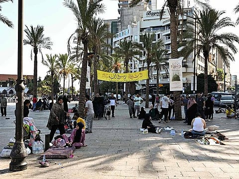 People who fled Israeli bombardment on Beirut's southern suburbs, gather along the Lebanese capital's seaside corniche where they spent the night, on September 28, 2024.