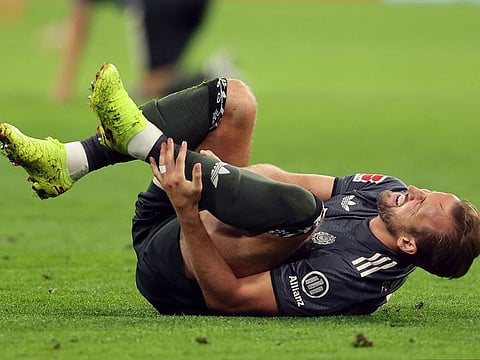 Bayern Munich's English forward #09 Harry Kane reacts injured on the ground during the German first division Bundesliga football match between FC Bayern Munich and Bayer 04 Leverkusen in Munich, southern Germany on September 28, 2024.