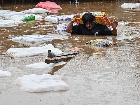 A man carrying a sack of flour wades through flood waters after the Bagmati River overflowed following heavy monsoon rains in Kathmandu.