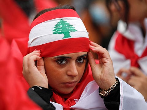A protester wears a Lebanese flag during a demonstration in support of Lebanese people as intense Israeli attacks across Lebanon's east, south and on southern Beirut have killed hundreds of people and forced many to flee their homes, on Place de la Republique, in Paris, on September 29, 2024.