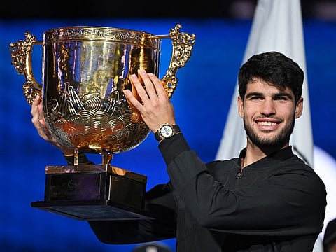 Spains Carlos Alcaraz celebrates with the trophy after winning the mens singles final against Italys Jannik Sinner at the China Open tennis tournament in Beijing on Wednesday.