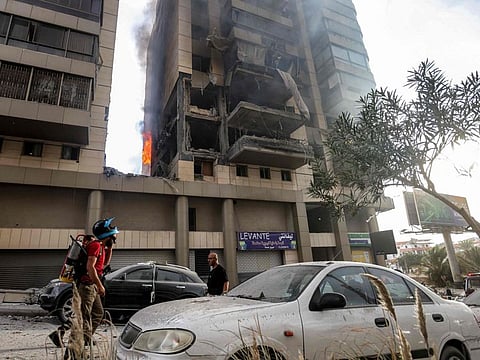 A Lebanese civil defence firefighter walks at the scene of an Israeli airstrike that targeted an apartment building in south Beirut Jnah neighbourhood on October 1, 2024.