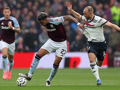 Aston Villa's English midfielder Morgan Rogers tugs on the shirt of Manchester United's Danish midfielder Christian Eriksen during the English Premier League football match at Villa Park in Birmingham, central England on Sunday.