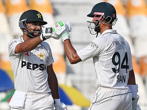Pakistan's Abdullah Shafique celebrates wtih his captain Shan Masood (right) after scoring a century during the first day of the first Test cricket match against England at the Multan Cricket Stadium in Multan on Monday.