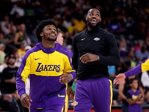 Bronny James (left) and LeBron James of the Los Angeles Lakers warm up prior to the game against the Phoenix Suns at Acrisure Arena on Sunday.