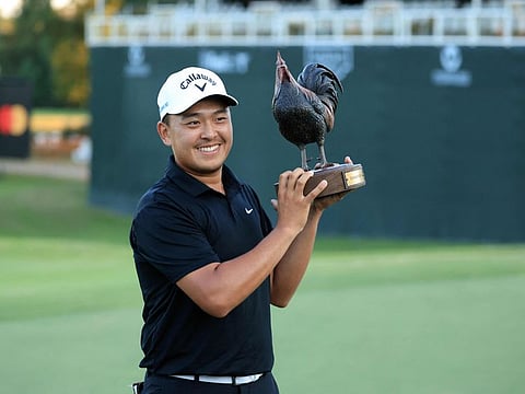 Kevin Yu of Chinese Taipei poses with the trophy on the 18th green after winning PGA Tour event in a playoff on Sunday.