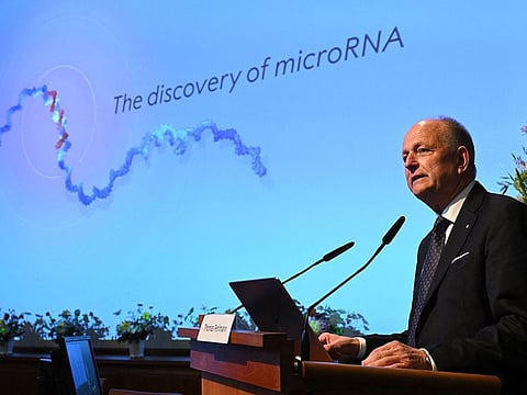 Member of the Nobel Assembly Olle Kaempe speaks to the media in front of a screen displaying results of the research of this year's laureates Victor Ambros and Gary Ruvkum during the announcement of the winners of the 2024 Nobel Prize in Physiology or Medicine at the Karolinska Institute in Stockholm on October 7, 2024.
