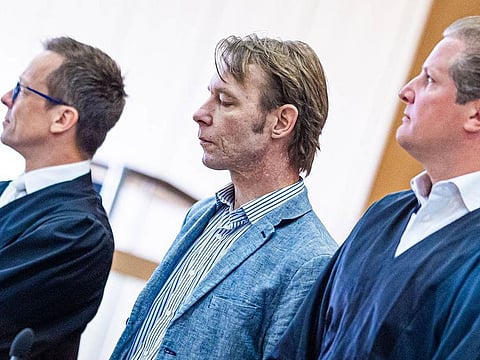 In this file photo taken on July 5, 2024 defendant Christian B (C) is seen between his lawyers Holm Putzke (L) und Friedrich Fuelscher (R) as he arrives for a session of his trial at court in Braunschweig, northern Germany.