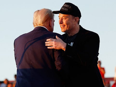 Elon Musk embraces Republican presidential nominee, former President Donald Trump during a campaign rally at the Butler Farm Show fairgrounds on October 05, 2024 in Butler, Pennsylvania.