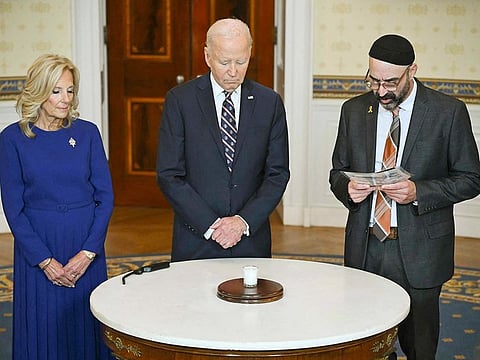 US President Joe Biden, First Lady Jill Biden, and Rabbi Aaron Alexander of Adas Israel Congregation mark one year since Hamas's attack on Israel during a yahrzeit candle lighting in the Blue Room of the White House in Washington, DC, on October 7, 2024.