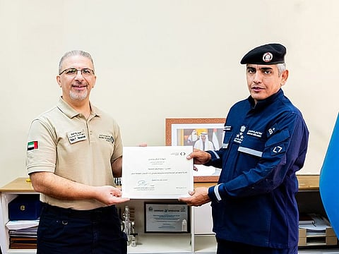 Rabi Farouk Masarwa (L) being honoured by Brigadier Mohsen Saeed Al Mansouri, Director of the Emergency and Public Safety Sector