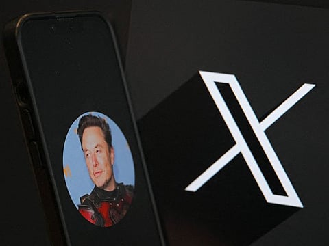 This illustration photograph shows the logo of social network X (formerly Twitter) and a photograph of CEO of social network X, Elon Musk displayed on a smartphone.