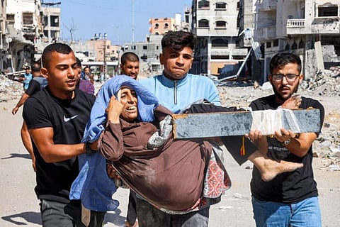 Men carry injured woman to be evacuated in the Jabalia camp for Palestinian refugees in the northern Gaza Strip on October 9, 2024 amid the ongoing war in the Palestinian territory between Israel and Hamas.