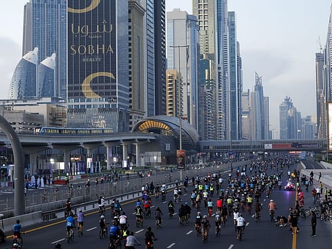 Thousands of cycling enthusiasts ride past Sheikh Zayed Road as part of Dubai Ride during Dubai Fitness Challenge 2023. 12th November 2023