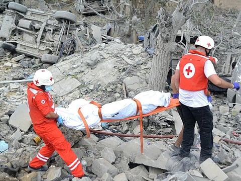Paramedics with the Lebanese Red Cross transport a body unearthed from the rubble at the site of an Israeli airstrike that targeted the northern Lebanese village of Aito on October 14, 2024.