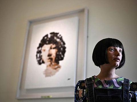 Ultra-realistic AI robot Ai-Da poses in front of a painting she made during the press preview of the London Design Biennale 2023 at Somerset House, central London.