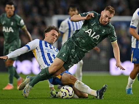 Tottenham Hotspur's Swedish midfielder Dejan Kulusevski (right) is tackled by Brighton's Dutch defender Mats Wieffer during the English Premier League football match at the American Express Community Stadium in Brighton, southern England on October 6.
