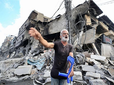 A man holds his crutches as he reacts in front amid the destruction a day after Israeli airstrikes that targeted the southern Lebanese city of Nabatieh on October 17, 2024.