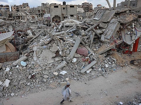 A man walks past destroyed buildings in Khan Yunis in the southern Gaza Strip on October 17, 2024, amid the ongoing war between Israel and the Palestinian militant group Hamas in the besieged Palestinian territory.