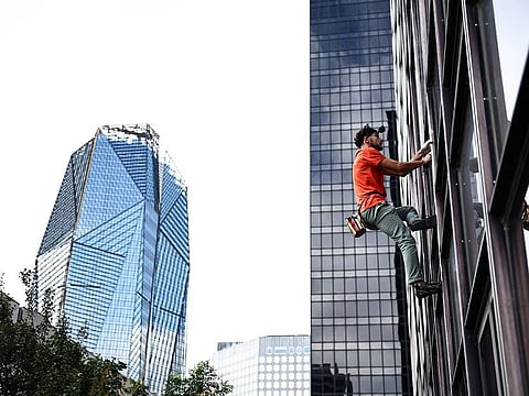 French urban climber Titouan Leduc begins climbing the Franklin Tower, a 115-metre-high office skyscraper located in La Defense business district, west of Paris, on October 3, 2024.