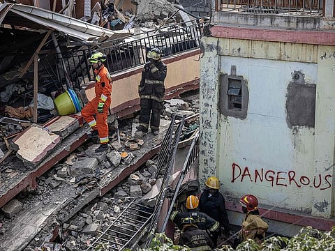 Nairobi County emergency responders and a member of the Polish Aid look for people feared to be trapped under a collapsed residential building at Kahawa West residential area in Nairobi.