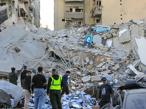 People inspect the damage at the site of an overnight Israeli airstrike that targeted a branch of the Al Qard Al Hassan charity in Beiruts southern suburbs on October 21, 2024.