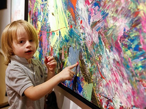 Laurent Schwarz, three years old, explains his artwork in his parents' house in Neubeuern near Rosenheim, southern Germany on October 17, 2024.