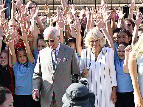 Britain's King Charles III (centre, L) and Queen Camilla (centre, R) pose for a photograph with members of the public at the Sydney Opera House in Sydney on October 22, 2024.