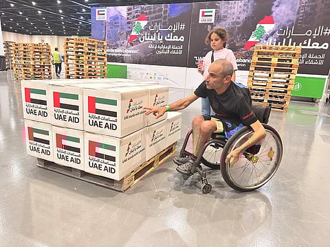 Morad Shadeed overseeing the packaged boxes during the UAE Stands with Lebanon aid campaign as his daughter looks on at Expo City Dubai on Sunday.