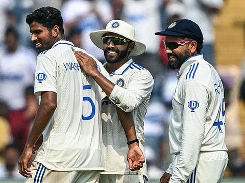 India's Washington Sundar celebrates with his skipper Rohit Sharma (right) and Ravindra Jadeja after dismissing New Zealand's Rachin Ravindra during the first day of the second Test in Pune.