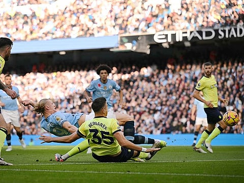 Manchester City's striker Erling Haaland (2nd L) falls backward as he scores the opening goal during the English Premier League football match against Southampton at the Etihad Stadium in Manchester, north west England, on October 26, 2024.