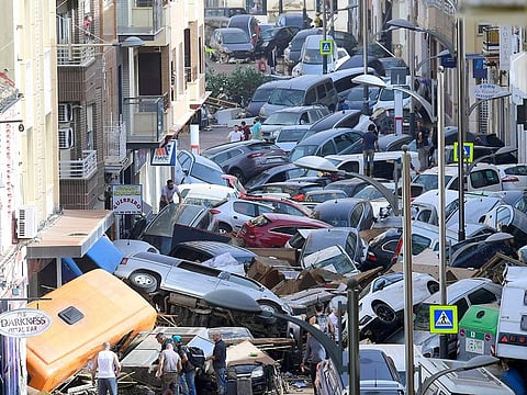Pedestrians stand next to piled up cars following deadly floods in Sedavi, south of Valencia, eastern Spain, on October 30, 2024.