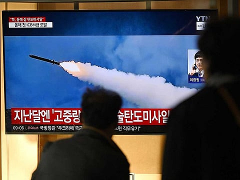 People watch a television screen showing a news broadcast with file footage of a North Korean missile test, at a train station in Seoul on October 31, 2024.