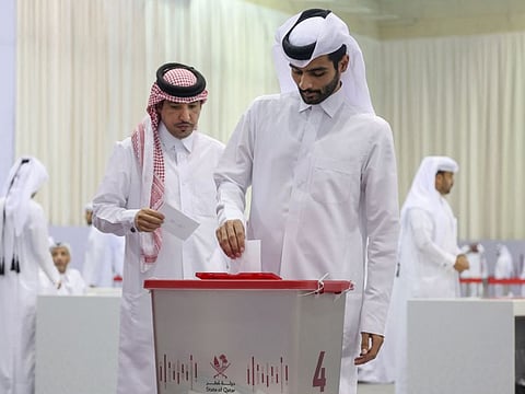 A Qatari voter casts his ballot at a polling station in Doha in a general referendum on constitutional amendments, including scrapping legislative council elections, on November 5, 2024.