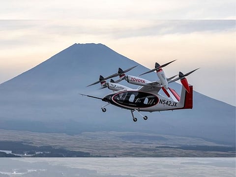 A Joby ‘air taxi’ flies with the majestic Mount Fuji serving as a breathtaking backdrop. Toyota has invested over $900 million in the eVTOL developer.