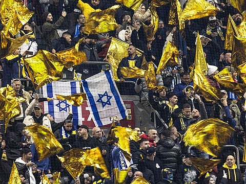 Maccabi supporters wave yellow flags next to Israeli flags during the UEFA Europa League, League phase - Matchday 4, football match between Ajax Amsterdam and Maccabi Tel Aviv at the Johan-Cruijff stadium, in Amsterdam on November 7, 2024.