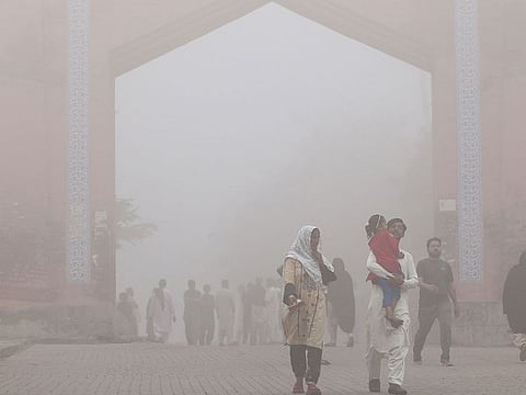 Visitors walk out from the Bhumi Fort amid heavy smoggy conditions in Multan.